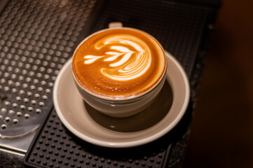 hot cappuccino with latte art on wood background
