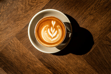 hot cappuccino with latte art on wood background