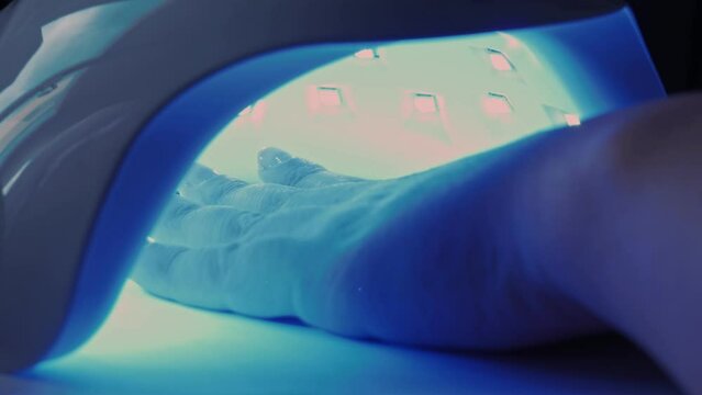 female hand under ultraviolet lamp