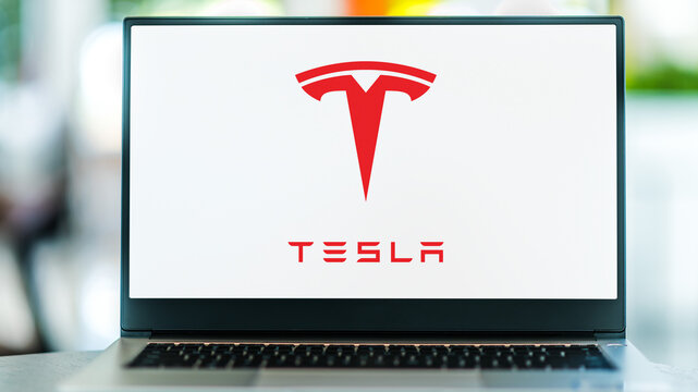 Laptop computer displaying logo of Tesla