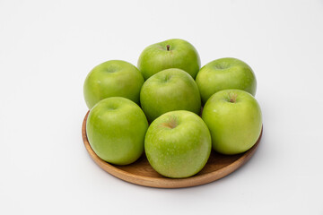 A lot of green apple on wooden tray on white background.
