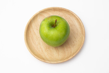 Green apple on wooden tray on white background.