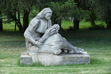 Old Soviet Post Socialism Statue of sad sitting farm worker woman holding Wheat harvest on stone...