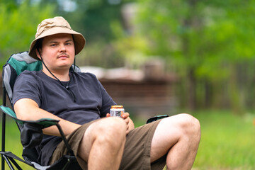 Young man relaxing while sitting in a chair outdoors - Powered by Adobe