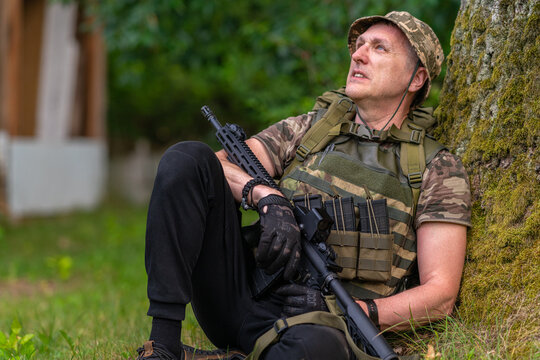 A man with a gun laid-back looks into the distance