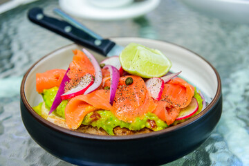Salmon with avocado paste and toast bread, healthy breakfast meal, close up image.