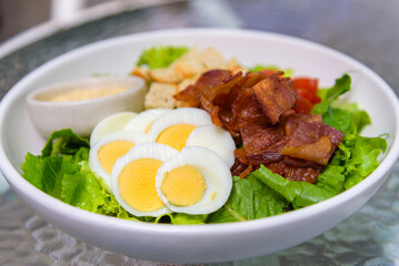 Salad with eggs, bacon and crouton, healthy food cuisine meal.