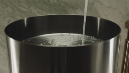 Pouring splashing of washing water in sink . Water pours from tap. Water stream going down the drain.  Clear, clean water flows from the tap. Footage for plumbing system service advertisement