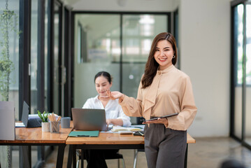 Obraz premium Smart asian business woman, company worker standing smile and holding digital tablet.
