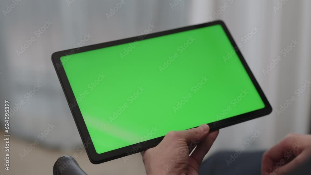 Sticker man sitting indoors on a chair with tablet pc with green screen