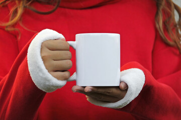 Girl is holding white 11 oz mug in hands with Christmas sweatshirt . Blank white ceramic cup