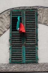 Italienisches Flair: Grüne Fensterläden mit einer eingesteckten italienischen Flagge in Siena, der zauberhaften Toskana