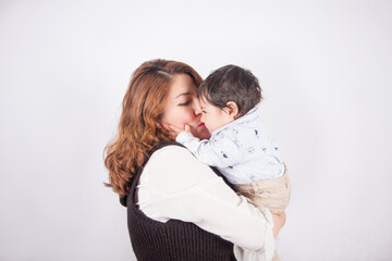 Beautiful photo of loving mom with baby on light photo studio background. Family and baby concept.