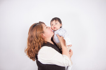 Fototapeta premium Beautiful photo of loving mom with baby on light photo studio background. Family and baby concept.