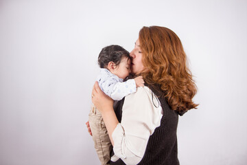 Fototapeta premium Beautiful photo of loving mom with baby on light photo studio background. Family and baby concept.