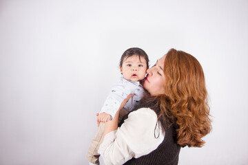 Beautiful photo of loving mom with baby on light photo studio background. Family and baby concept.
