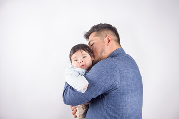 Fototapeta premium Beautiful photo of dad holding baby on light photo studio background. Family and baby concept.