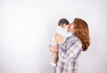 Beautiful photo of mom holding baby on light background in photo studio. Family and baby concept.