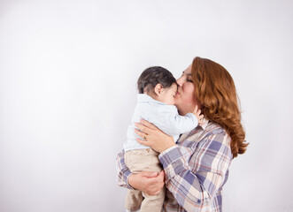 Beautiful photo of mom holding baby on light background in photo studio. Family and baby concept.