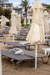 Beach in Antalya, Turkiye. Umbrellas and sun loungers in the assembled state on the beach.
