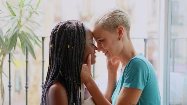 Lesbian couple about to kiss passionately on the balcony