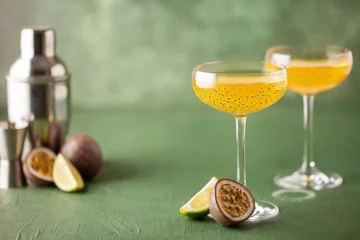 Fotobehang Passion fruit martini cocktail. Sour alcoholic drink with fresh passion fruit and lime, with bar tools. © murziknata