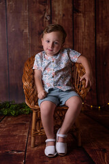 Portrait of sitting boy, isolated on wooden background
