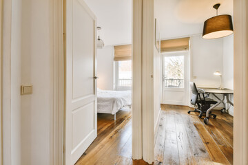 a room with wood flooring and white walls, two doors open to reveal the bedroom's closet space