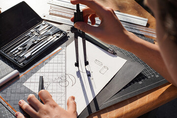 Architect and designer working accurately on a project drawing sketches and technical drafts on...