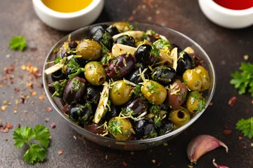 Fototapeten Marinated olives with fresh herbs, garlic, red wine vinegar and lemon zest © grinchh