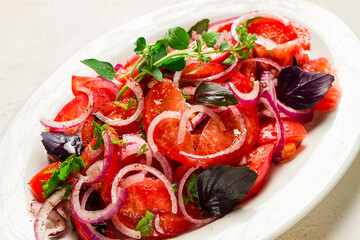 fresh tomato salad, with red onion, spices and herbs, top view, close-up, homemade,