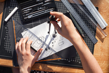 Architect and designer working accurately on a project drawing sketches and technical drafts on...