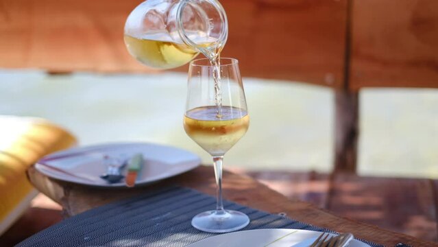 Home white wine pouring into a glass on a beach, Albania. High quality 4K footage