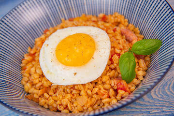 RECIPE FOR BLE WITH BACON, TOMATO AND SHALLOTS, SERVED WITH FRIED EGG. High quality photo