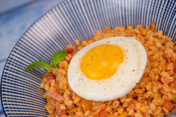 RECIPE FOR BLE WITH BACON, TOMATO AND SHALLOTS, SERVED WITH FRIED EGG. High quality photo
