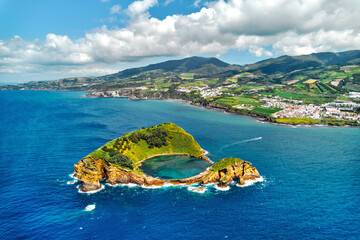 Aerial shot, drone point of view of picturesque Islet of Vila Franca do Campo. Sao Miguel island, Azores, Portugal. Heart carved by nature. Bird eye view. Travel attraction and natural wonders concept - 624131382