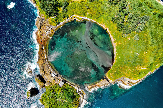 Aerial shot, drone point of view of picturesque Islet of Vila Franca do Campo. Sao Miguel island, Azores, Portugal. Heart carved by nature. Bird eye view. Travel attraction and natural wonders concept