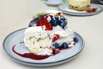 meringue cake with various berries as delicious dessert in cafe
