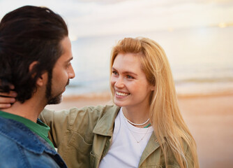 Obraz premium Happy Young Couple Embracing While Having Romantic Date On The Beach