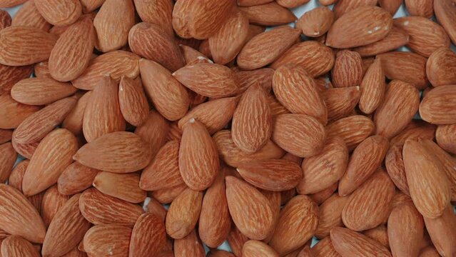 Close-up of organic, peeled almonds falling on table.. Nutty, crunchy snack packed with protein and vitamins. Concept of healthy eating and nutrition.
