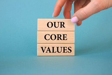 Our core values symbol. Wooden blocks with words Our core values. Business man hand. Beautiful blue background. Business and Our core values concept. Copy space.