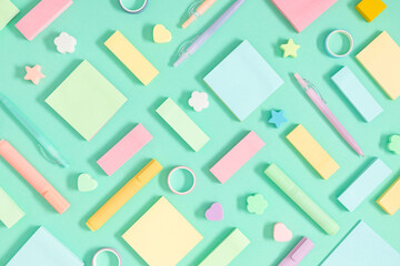 Back to school background. Flat lay, top view of colorful scattered stationery on isolated light green table background. School supplies on desk. Copyspace.