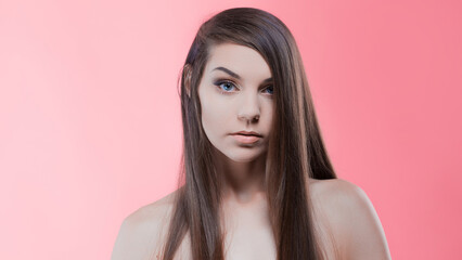 Naklejka premium Beauty portrait of brunette with perfect hair, on a pink background