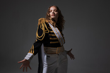 A glamorous blonde in a carnival uniform with epaulettes, posing with pretentious poses, a show host or a pop artist