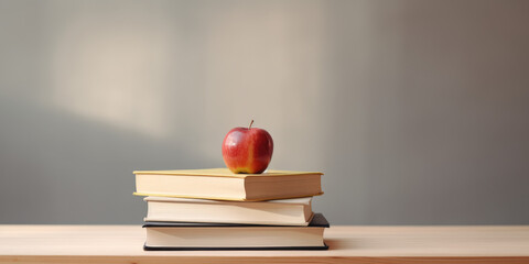 Stacked pile of books with an apple on top, symbolizing knowledge and academic success, set against a minimalist background with copy space. Education inspiration and personal growth