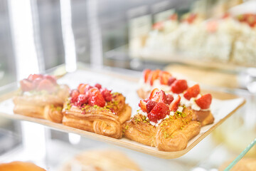 fresh pastries with berries. A variety of fresh pastries in the bakery window. almond croissant is fresh and hot in a cafe next to other types of pastries. The interior of an Italian restaurant.