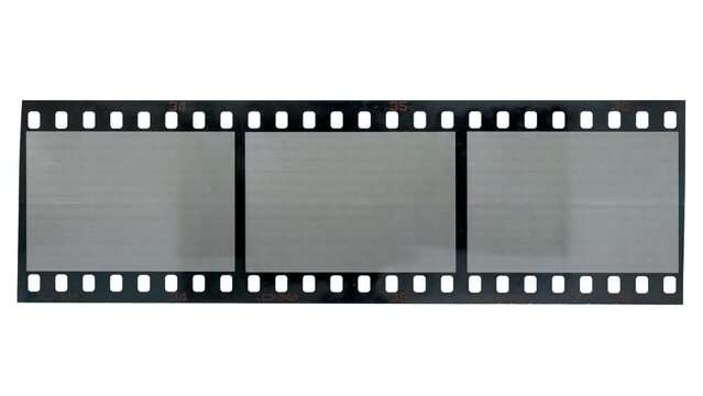 bright light shining over long 35mm filmstrip with three empty frames.