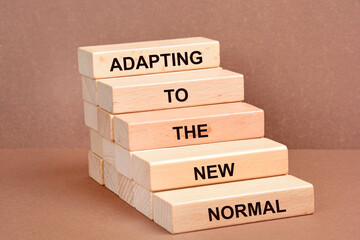 Adapting to the new normal words on a wooden blocks