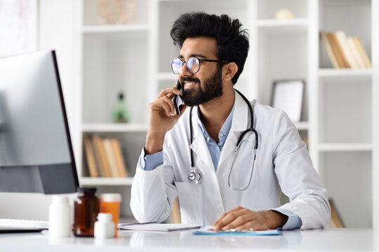 Handsome middle eastern young doctor have phone conversation with patient