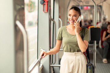 Happy Passenger Lady Talking On Cellphone Standing In Tram Inside